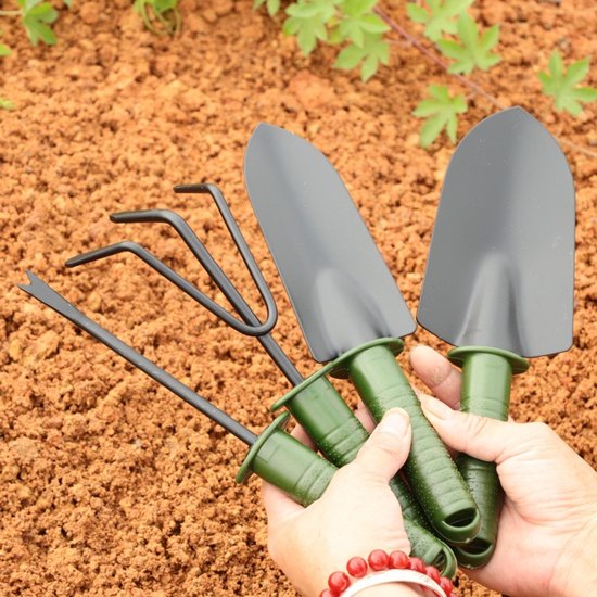 Een vierdelige tuingereedschapset, bestaande uit een schep voor het planten van bloemen en groenten, een tuinschep voor het wieden, een tuinhark en een tuingereedschapset met een plastic handvat. van Merkloos	